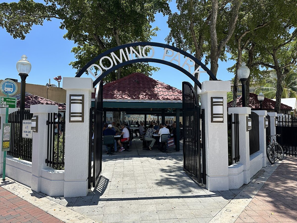 The entrance arch at Domino Park on Calle Ocho, with players at the tables inside